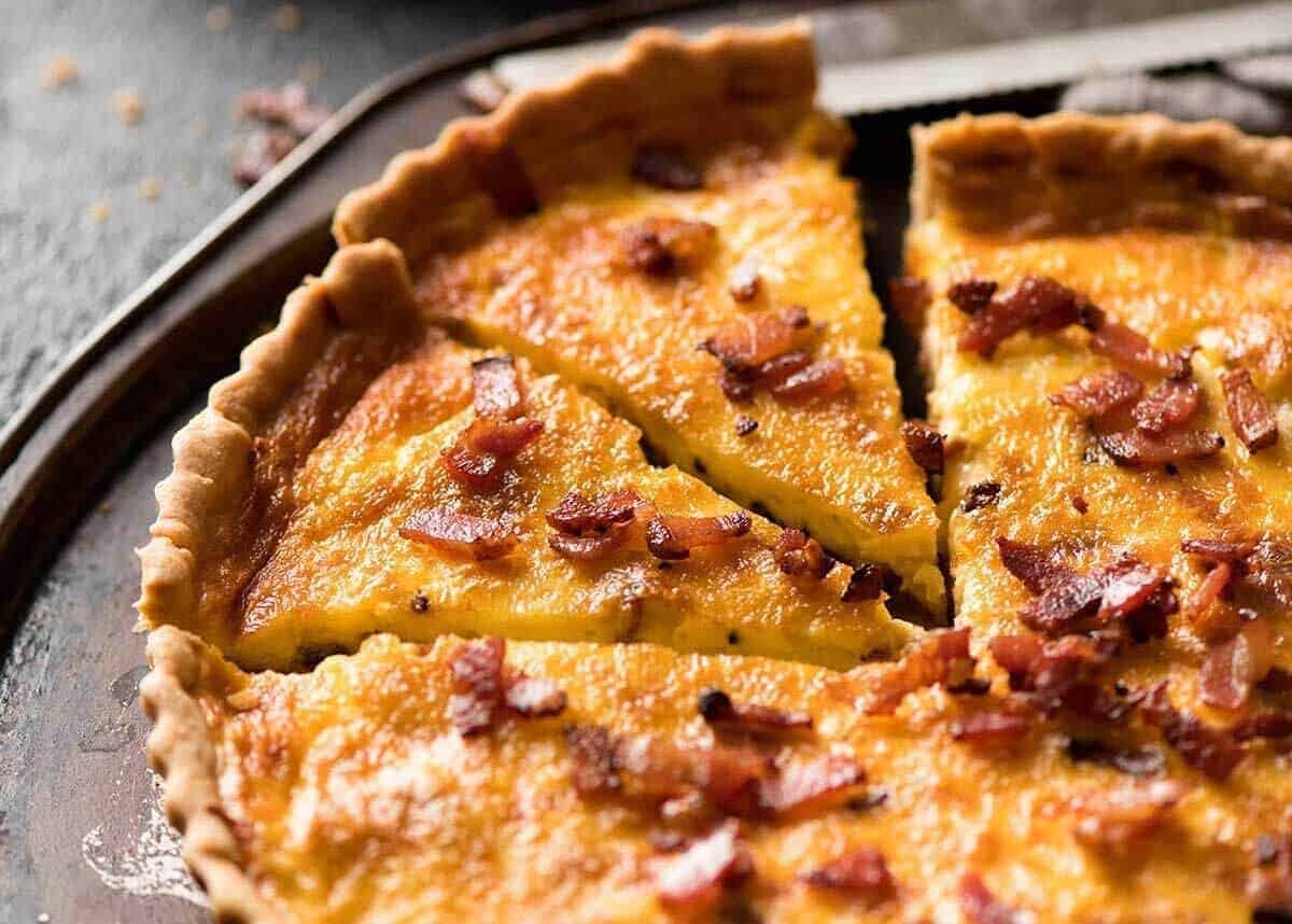 Foto de quiche lorraine en una bandeja rústica de metal para servir