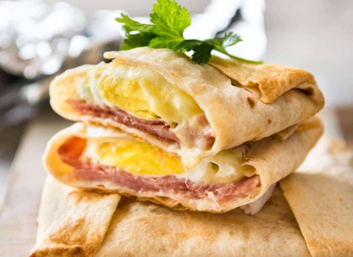 Batería de jamón caliente, bolsillos de huevo y queso hechos con tortillas cortadas para mostrar el interior con queso derretido y huevos perfectamente cocidos.