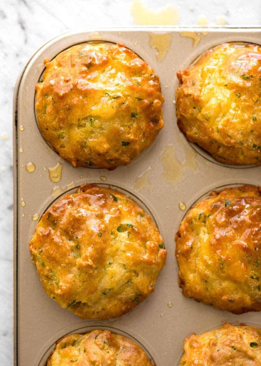 Foto sobre muffins de queso salado dorado en una caja de muffins dorado.