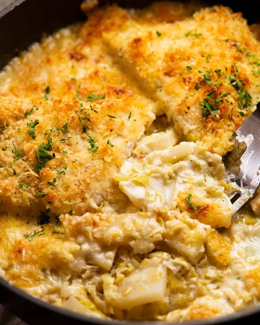 Sacando pescado cremoso en la papa gratina